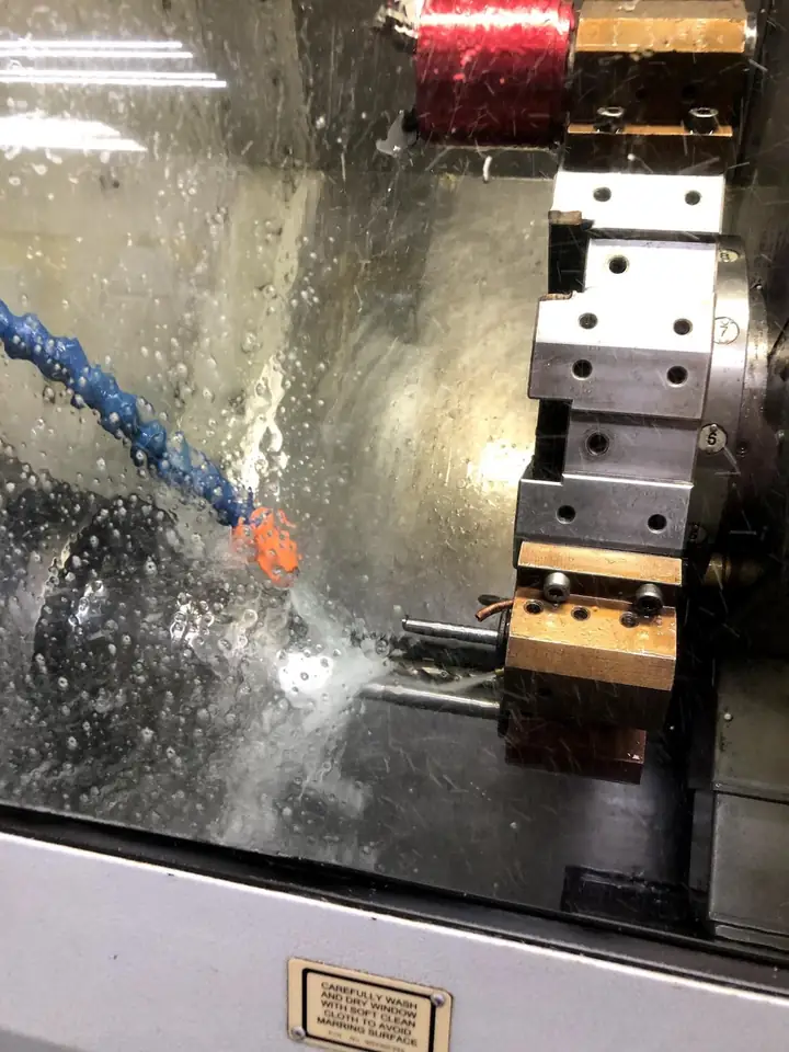CNC lathe machining a polymer part.