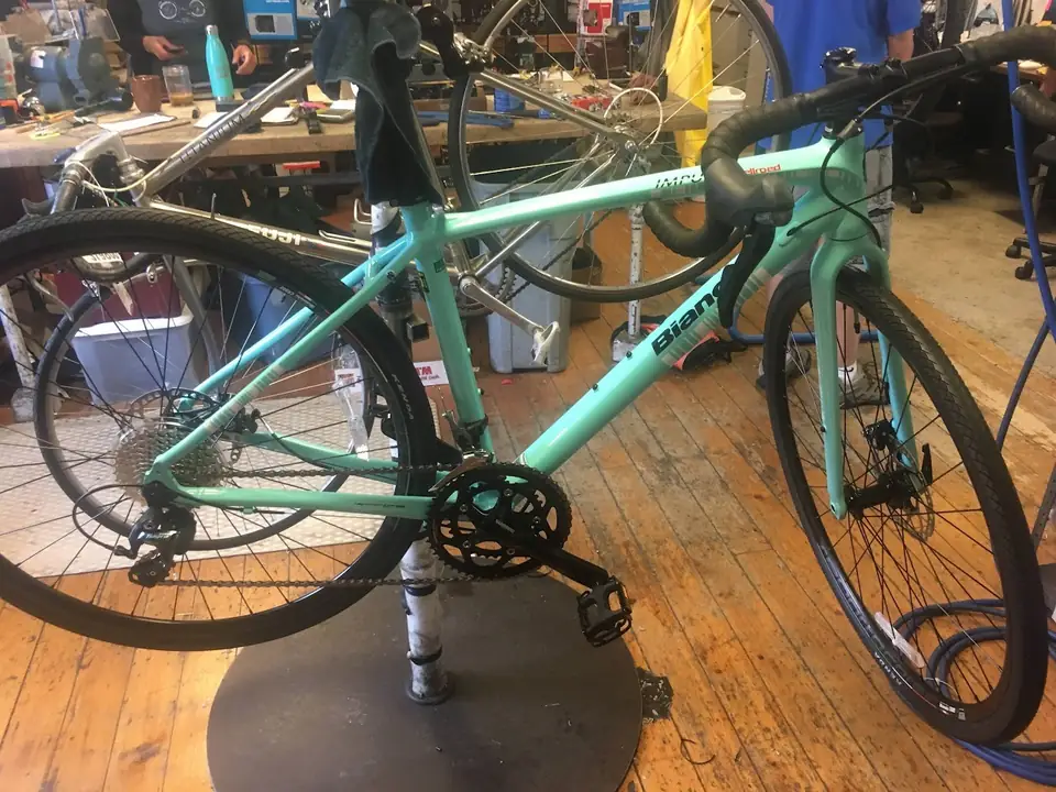 Turquoise bicycle being assembled in the shop.