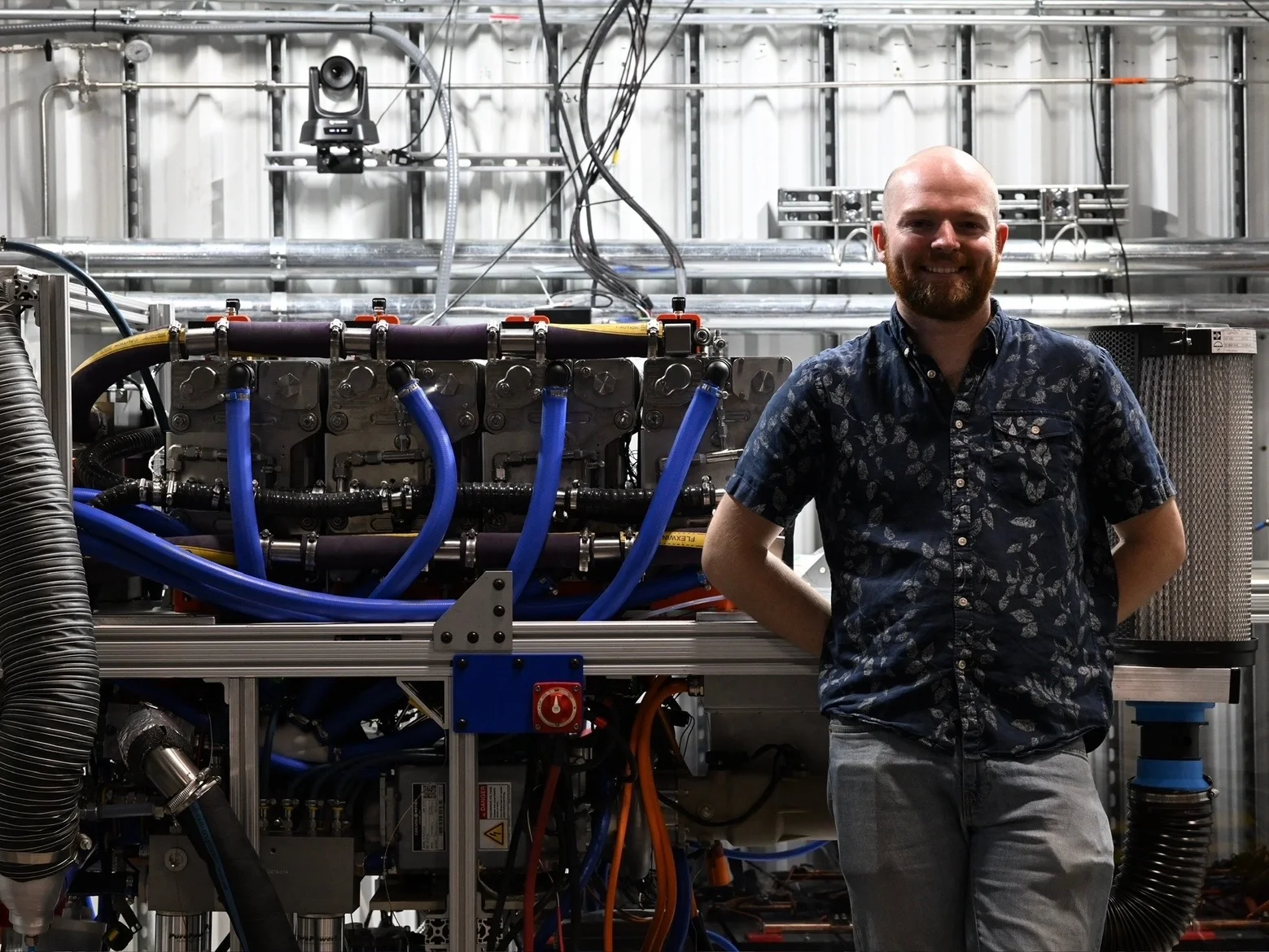 Standing beside a Nimbus fuel-cell system in the laboratory.